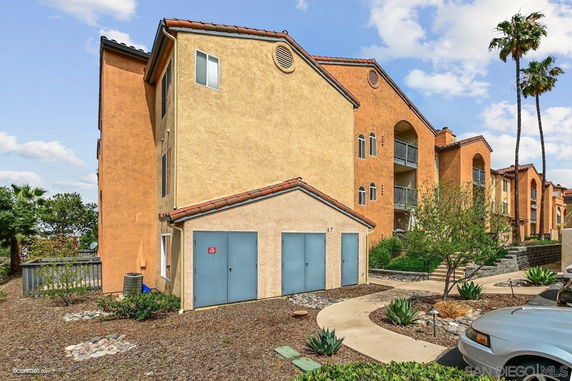 Front view of a multi-story apartment building with orange and beige walls and balconies.