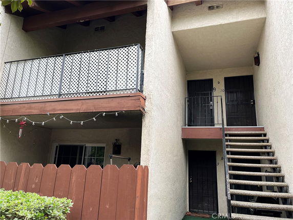 Front view of a multi-story building with a balcony and staircase.