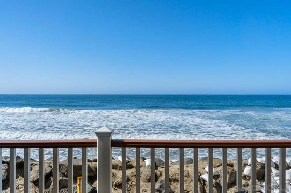 Panoramic view of the ocean from a wooden railing.