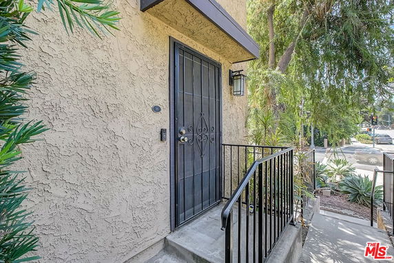 Front view of a house entrance with a metal door and railing.