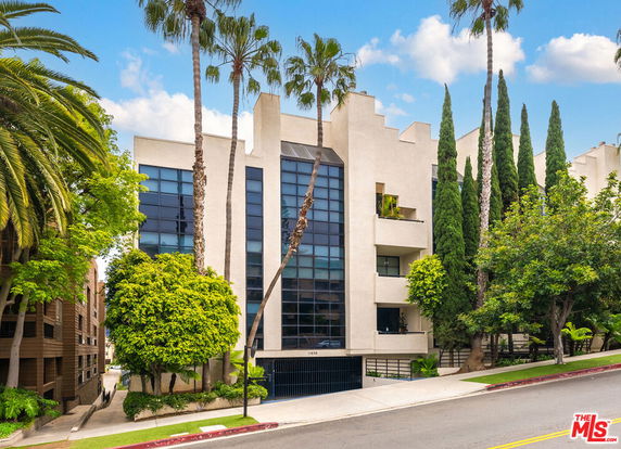 Front view of a multi-story building with large windows and a modern design.
