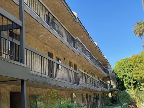 Angled view of a multi-story building with balconies and external staircases.