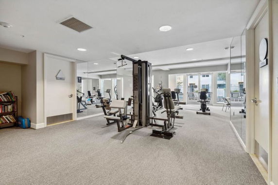 Indoor gym area with exercise equipment and mirrors.