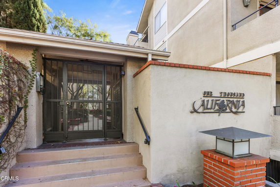Front view of a building entrance with gated doors and a sign saying 'One Thousand California.'