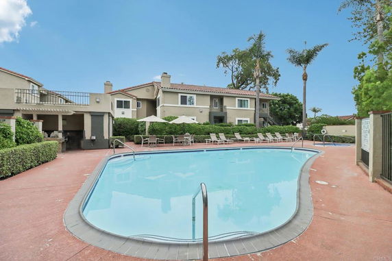 Swimming pool area with residential buildings in the background.