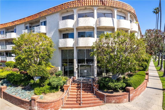 Front view of a multi-story building with a curved facade and balconies.