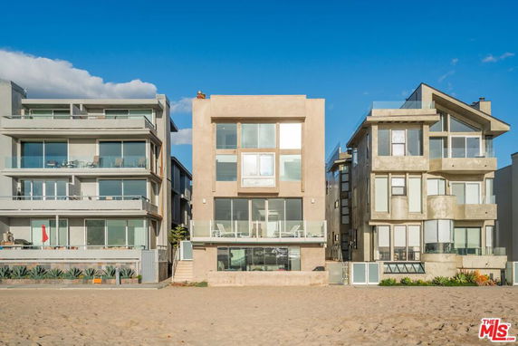 Front view of three multi-story beachfront houses.