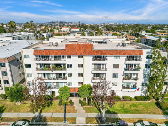 Front view of a multi-story apartment building with balconies.