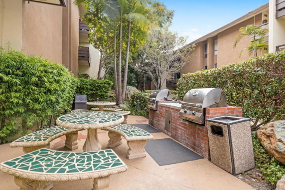 Outdoor area with barbecue grills and mosaic tables.