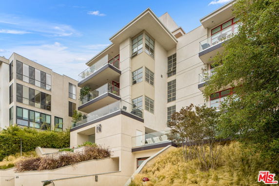 Front view of a multi-story modern building with balconies.