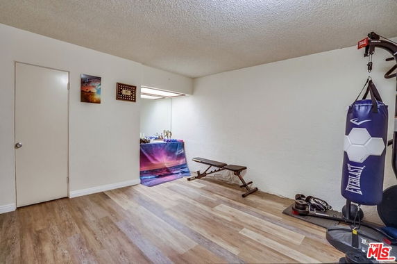 Room with gym equipment and punching bag.