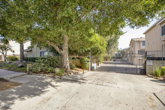 Front view of a multi-story residential building with a gated entrance.