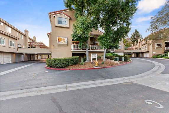 Front view of a multi-story townhouse complex with garage parking.