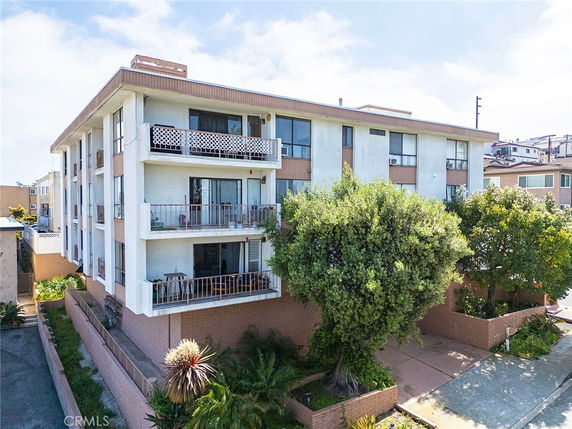 Front view of a multi-story apartment building with balconies.