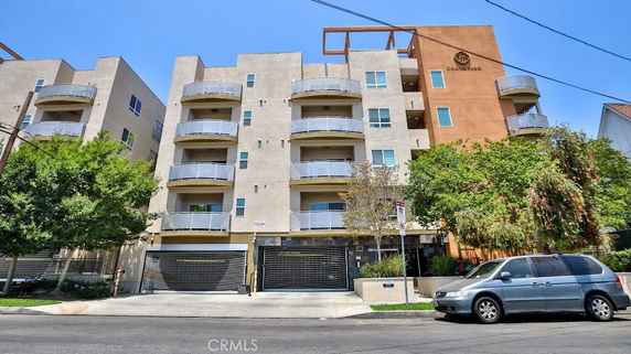 Front view of a multi-story apartment building with balconies.