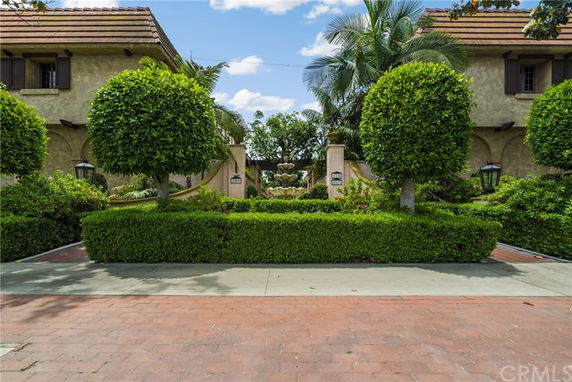 Front view of a house with a tiled roof and trimmed hedges.