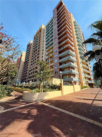 Front view of a multi-story apartment building with balconies.