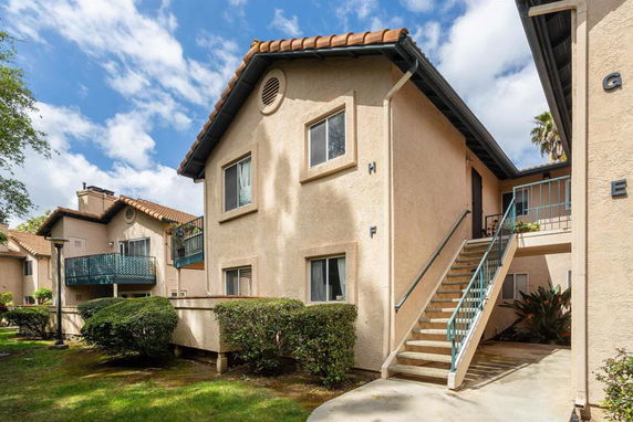 Front view of a two-story apartment building with external staircase.