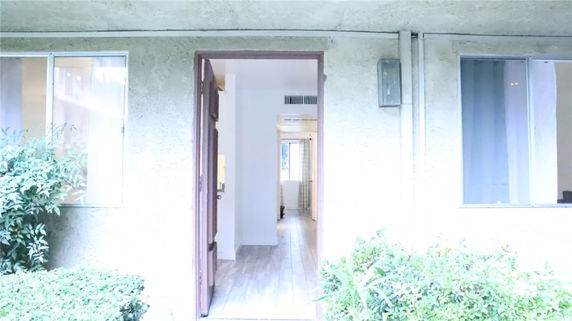 Front view of a building entrance with an open door and adjacent windows.