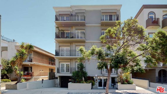 Front view of a multi-story building with multiple balconies.