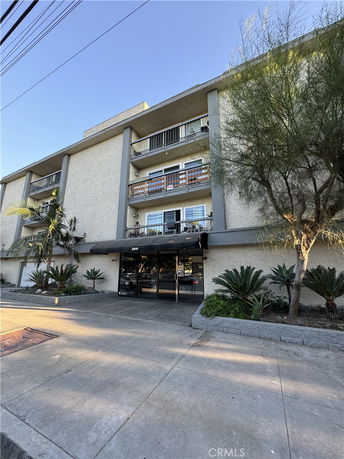 Front view of a multi-story building with balconies and a main entrance.
