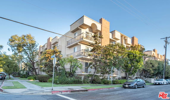 Front view of a multi-story apartment building with balconies.
