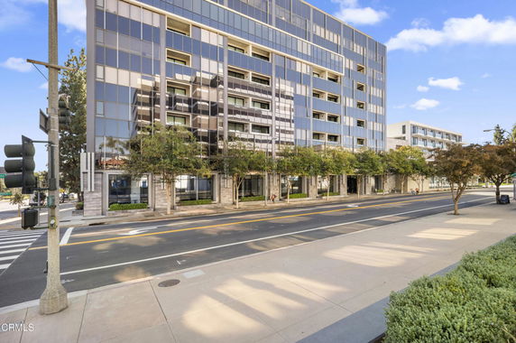 Front view of a multi-story modern building with a glass facade.