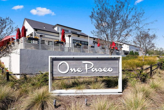Front view of a commercial building with a terrace and sign reading 'One Paseo'.