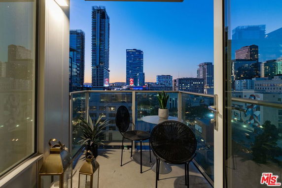 Panoramic view from a balcony overlooking a city skyline at dusk.