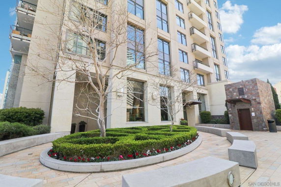 Front view of a multi-story building with large windows and a landscaped entrance.