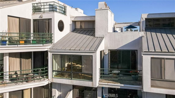 Front view of a multi-story building with multiple balconies and large glass windows.