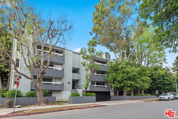Front view of a modern multi-story apartment building with balconies.