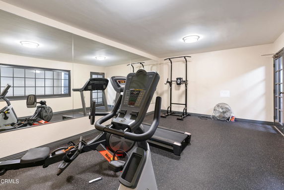 Indoor gym area with exercise equipment and mirrors.
