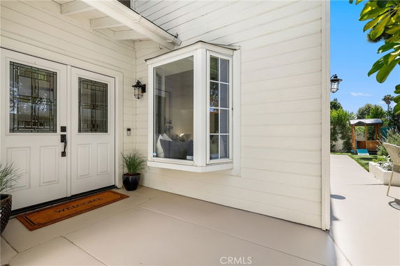 Front view of a house entrance with double doors and a bay window.