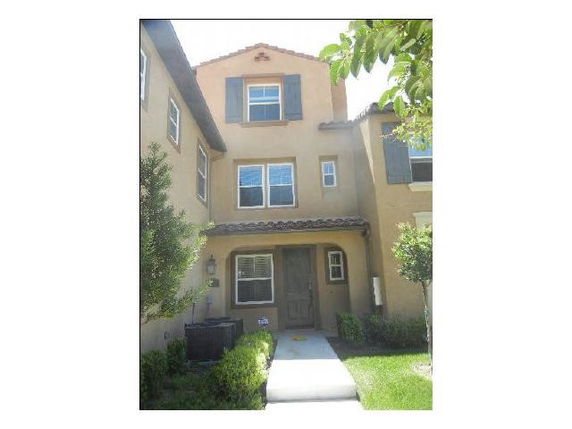 Front view of a multi-story house with a tiled roof and shutters.