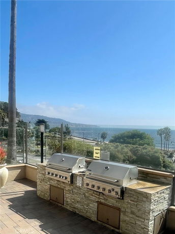 Outdoor area with built-in grills offering a panoramic view of the coastline and ocean.