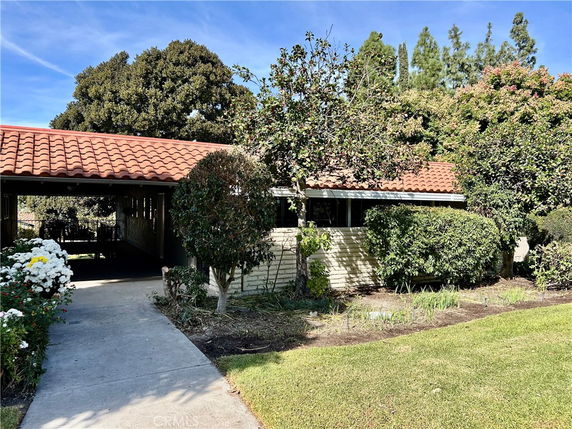 Front view of a single-story house with a tiled roof and covered walkway.