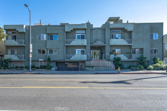 Front view of a three-story apartment building with balconies.