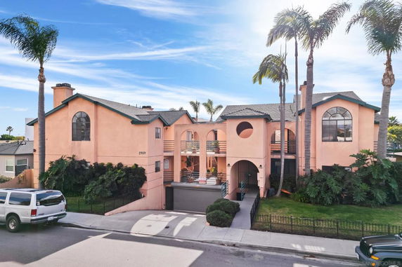 Front view of a two-story house with arched windows and a garage entrance.