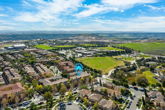 Aerial panoramic view of a suburban area with houses and green fields.