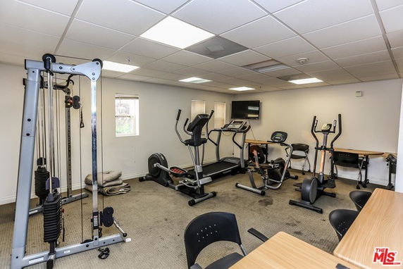 Room equipped with gym exercise machines and equipment.