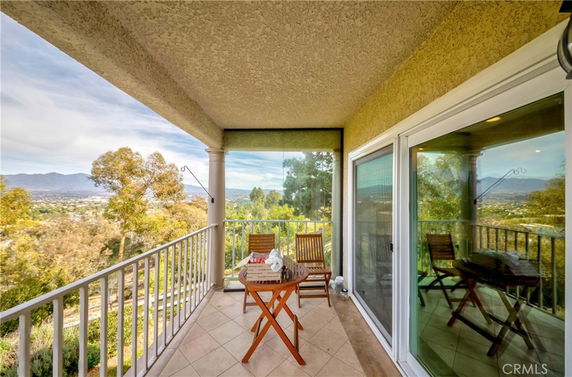 View from a balcony with outdoor seating and scenic surroundings.