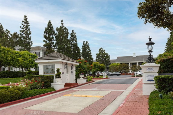 Entrance gatehouse to a residential property with two-story building in the background.