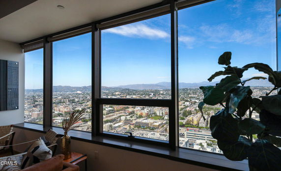 Panoramic view of cityscape seen from a high-rise apartment window.
