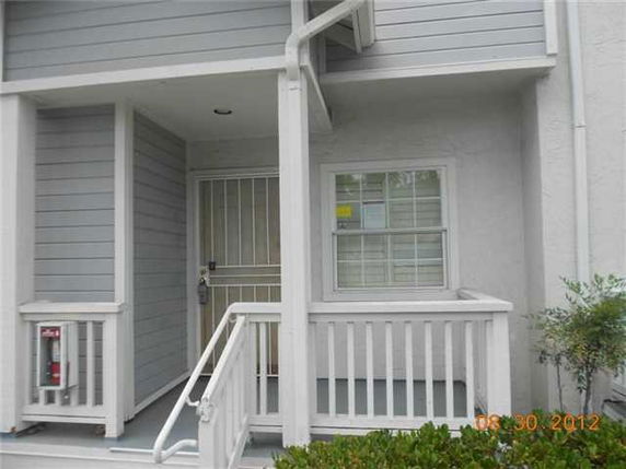 Front view of a residential building entrance with a small porch and white railings.