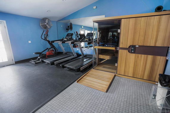 Indoor gym area with treadmills and a sauna room.