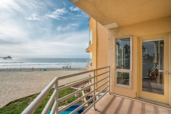 Balcony view from a beachfront building overlooking the ocean and beach.