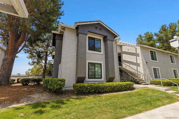 Front view of a two-story residential building with exterior stairs.
