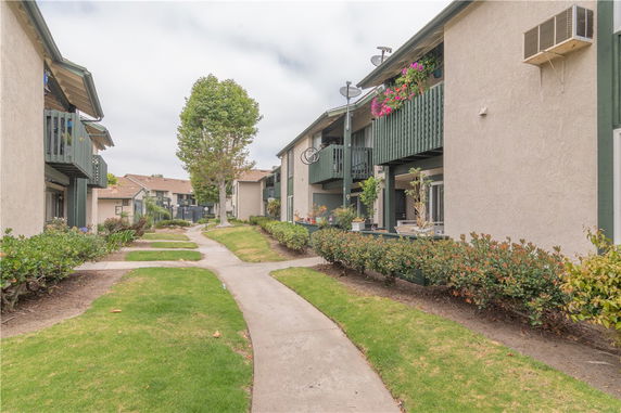 Front view of apartment buildings with balconies and landscaping.