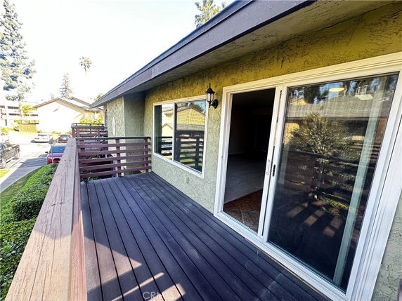 View from a balcony with sliding glass doors and wooden railing.